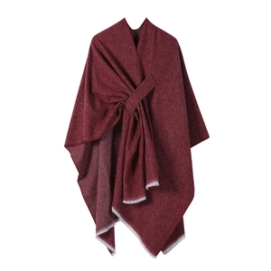 Detail view of burgundy knitted shawl with light fringe edge and stylish knot design