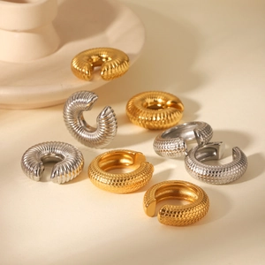 Macro shot of C-shaped textured ear cuffs in gold and silver stainless steel finishes