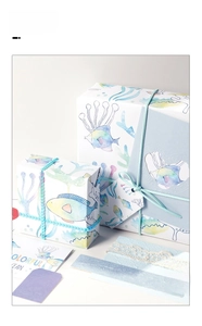 Detailed view of watercolor ocean fish gift wrap set with blue ribbons and lace