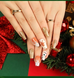 Detailed view of coffin Christmas nails with gingerbread and candy cane patterns