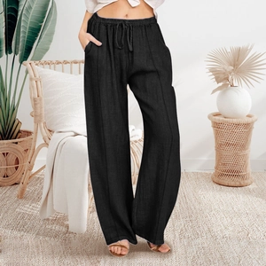 Detail of high-waisted black casual wide-leg trousers with drawstring and side pockets