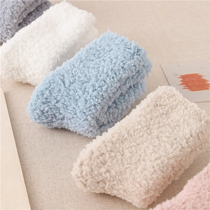 Nahaufnahme gerollter flauschiger Korallenvlies-Wintersocken in Blau, Weiß und Rosa