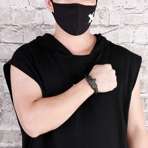 Close-up of men's braided leather bracelet with black metal wolf head on a male wrist