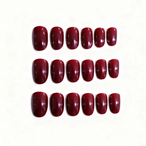Faux ongles ovales rouge cerise brillant de tailles variées sur fond blanc pur