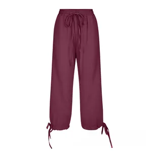Detail of wine red linen trousers featuring elastic drawstring waist and adjustable hem ties