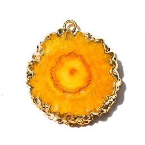 Natural yellow agate sunflower pendant with gold plated edge on white background