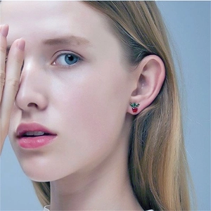 Close-up of elegant S925 silver strawberry stud earring worn on a model ear