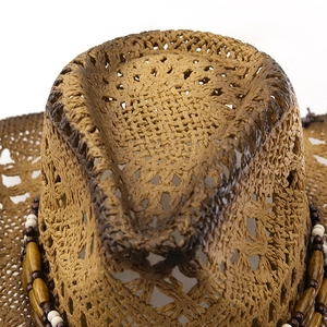 Close-up of a woven cowboy straw hat with ethnic wooden beads and hollow texture
