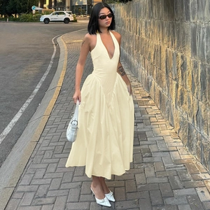 Nahaufnahme von rückenfreiem Neckholder-Maxikleid in Beige mit tiefem V-Ausschnitt