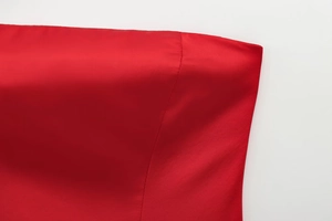Vue macro du tissu satiné rouge montrant des coutures de qualité et une texture lisse