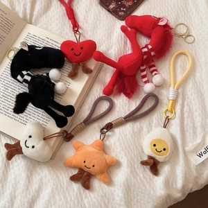 Plush pony pendants with stars and hearts on white fabric, diverse bag charm collection