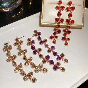 Elegant floral tassel dangle earrings with crystals in gold, purple, and red tones