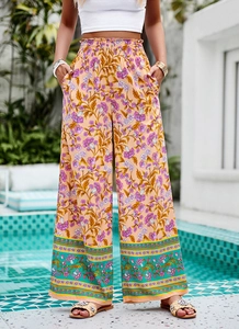 Gros plan sur l'imprimé floral rose et l'ourlet rayé coloré du pantalon large