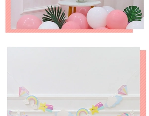 Rainbow unicorn birthday banner and balloons with tropical palm leaves party decor