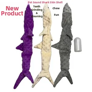 Detail of plush shark squeaky pet toy covers in purple, beige and grey with internal squeaker