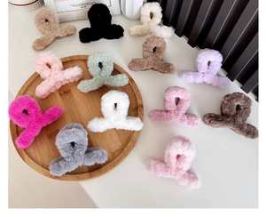 Various colors of plush faux rabbit fur hair claws displayed on a wooden tray