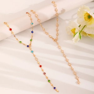 Elegant gold Y-shaped necklace with colorful crystals and pearls on white background