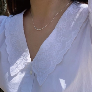 Detailed view of s925 silver snake bone chain necklace with olive beads on a model