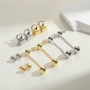 Detail shot of square gold and silver minimalist drop earrings with delicate chain tassels