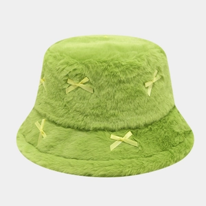 Close-up of green plush faux fur bucket hat with delicate yellow satin bows decoration