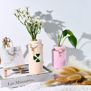 Four-leaf clover relief vase set with gold jewelry and pearl pendants in a cozy setting