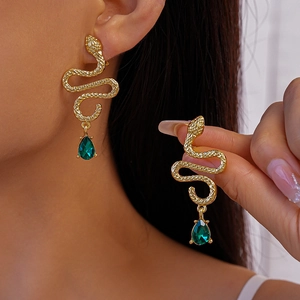 Golden snake earrings with green pear-shaped drop stone shown in elegant wear and detail