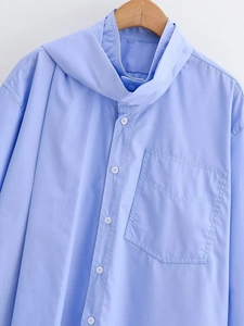 Close-up of light blue long-sleeve shirt with hooded collar and chest pocket detail