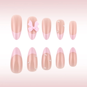 Detail of almond fake nails with pink French tips, tiny pearls, and 3D bow decoration