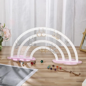 Detail of rainbow-shaped acrylic earring stand with white frame and pink cloud base