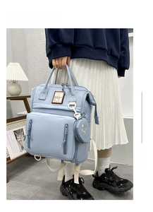 Close-up of light blue multi-functional diaper bag with dual zippers and heart pouch