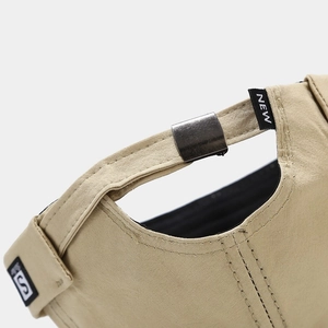 Close-up of adjustable metal buckle and S-label on the beige cotton docker hat