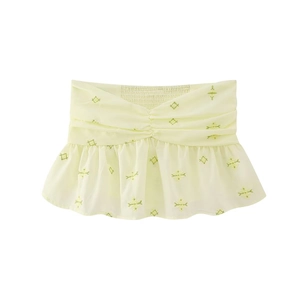 Détail du haut bandeau jaune avec poitrine plissée, ourlet à basque et broderie