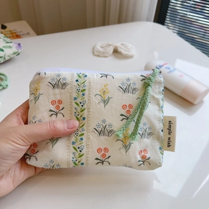 Handheld floral cotton mini storage bag with blue and green prints and zipper closure