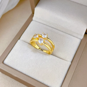 Close-up of gold three-layer ring with sparkling white zircon in beige jewelry box