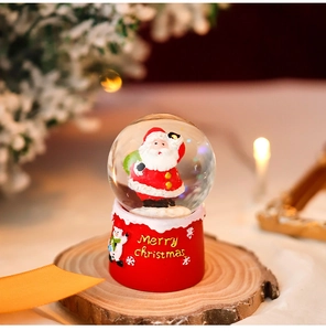 Detailed view of Santa Claus snow globe on a wooden base with warm holiday lights