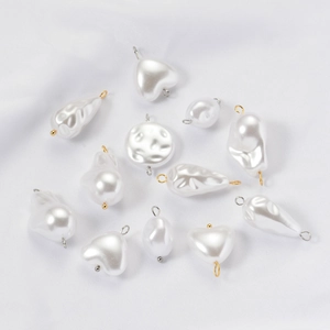 Flat lay of assorted white baroque pearl charms with gold and silver metal loops