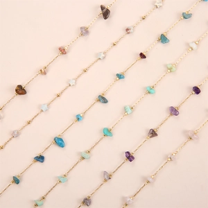 Macro view of colorful crushed stone beads and gold chains in bohemian style bracelet
