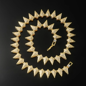 Macro detail of iced-out gold hip hop necklace with geometric spiked links on black surface