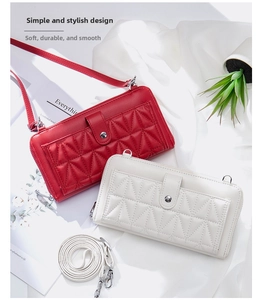 Detail view of quilted leather phone bags in red and ivory with detachable straps