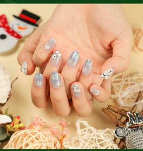 Detail of Christmas press-on nails with silver glitter, white snowflakes and 3D snowman art