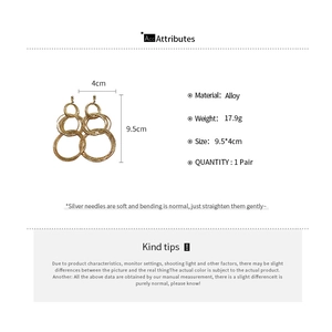 Detail showing oversized gold multi-layer hoop earrings with dimensions 9.5cm by 4cm