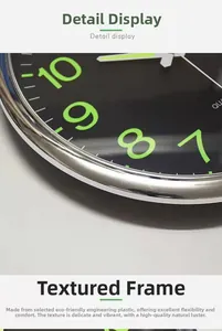 Detail of silver metallic frame and black dial with luminous green numerals on quartz clock