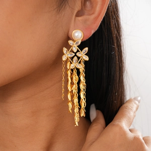 Detailed side view of 18K gold-plated floral pearl earrings with cascading leaf tassels
