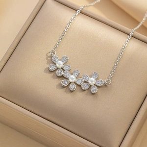 Silver flower necklace with sparkling zircon petals and pearls on a premium jewelry box