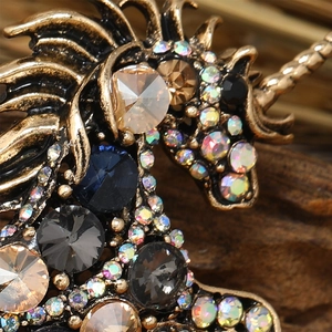 Macro shot of unicorn brooch with multicolor rhinestones and antique gold finish