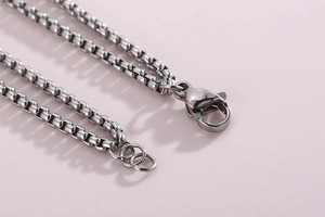 Macro view of silver titanium steel square link chain with secure lobster clasp closure