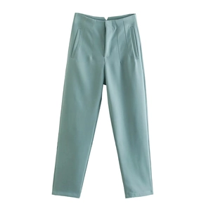 Detailed flat lay of mint green women trousers showing smooth fabric and premium texture