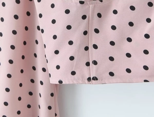 Détail du haut en mousseline rose à pois noirs montrant la couture et la texture du tissu