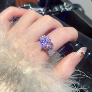 Detailed close-up of a heart-shaped pink zircon ring with diamond-encrusted silver band