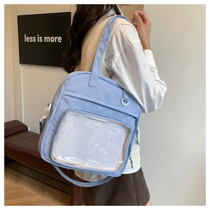 Detailed side view of a light blue nylon tote bag with a transparent front pocket